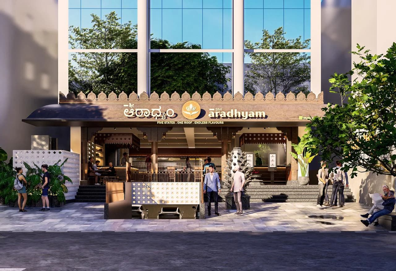 The Banashankari shopfront on Outer Ring Road: the lotus crest and the name in Kannada and English along the lit awning, the lotus bud parapet running above it, and the open front with its steps up from the pavement